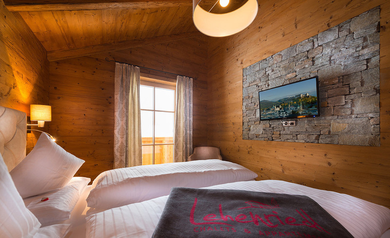 Das komfortable Schlafzimmer ist ausgestattet mit Fernseher und Balkon- Chaleturlaub in Salzburg