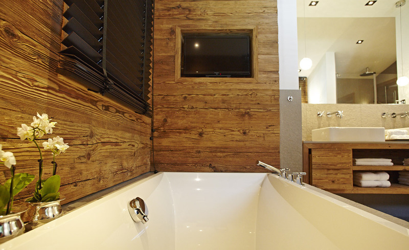 Design Chalet im Allgäu- Badezimmer mit Badewanne und Flachbild TV